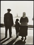 A young boy points out the Statue to his immigrant parents from Ellis Island.