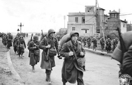 U.S. 45th Infantry Division soldiers march through Anzio on their way to the front.