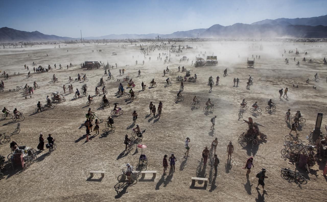 Festival goers kick up dust at Burning Man. Photo by Christopher Michel