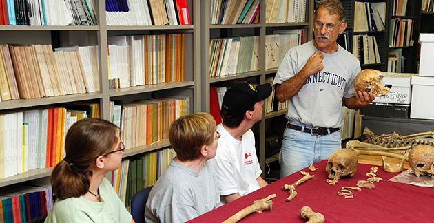 State Archaeologist Nicholas Bellantoni discusses skeletal remains with students at an archaeology field school session. University of Connecticut.