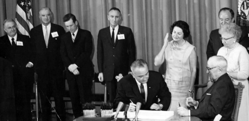 President Lyndon Johnson signed the Medicare Bill in 1965 at the Harry Truman Library as the former President and his wife Bess looked on.