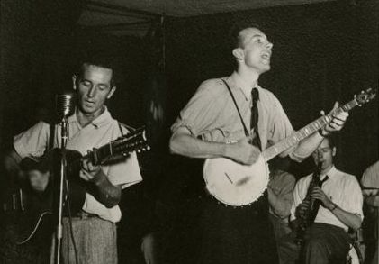 Pete Seeger modified "We Shall Overcome," and sang frequently with Woody Guthrie (left).