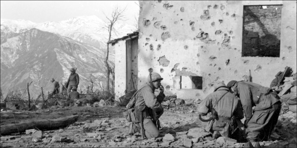 Soldiers pause on a hilltop while fighting their way north to Castel D'Aiano.