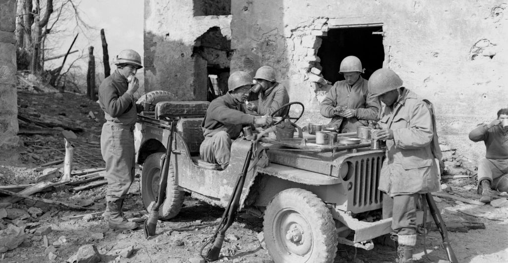 The engine of a jeep named "Marilyn" serves as a table for lunch.