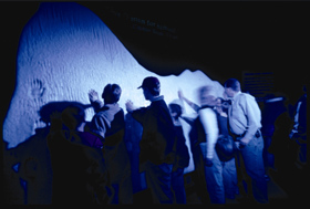Visitors touch the recreated iceberg at the show.