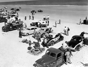 Mechanics look over their cars at Daytona Beach, 1952.