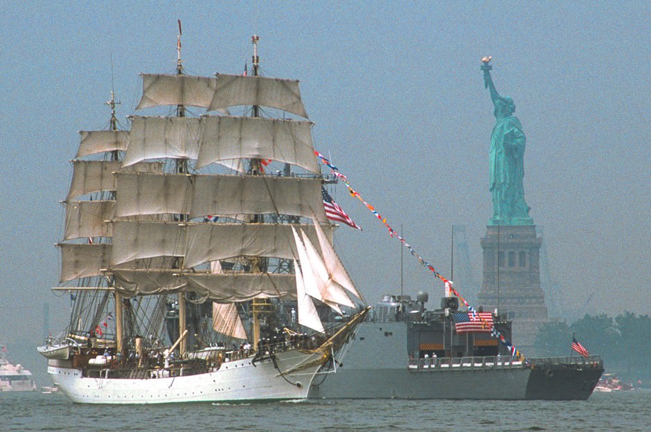A Tall Ship passes the reviewing ship and Statue of Liberty, Op Sail
