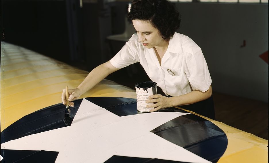 A worker paints an insignia on the wing of a Navy plane in Corpus Christi, Texas, in 1944.