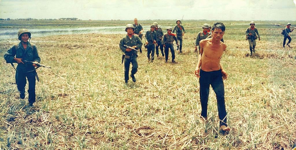 Vietnamese soldiers bring in a suspected Viet Cong guerilla