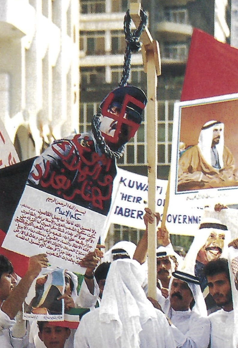 Kuwaiti exile brandishes a swastika-scrawled poster of Hussein at a demonstration in Abu Dhabi.
