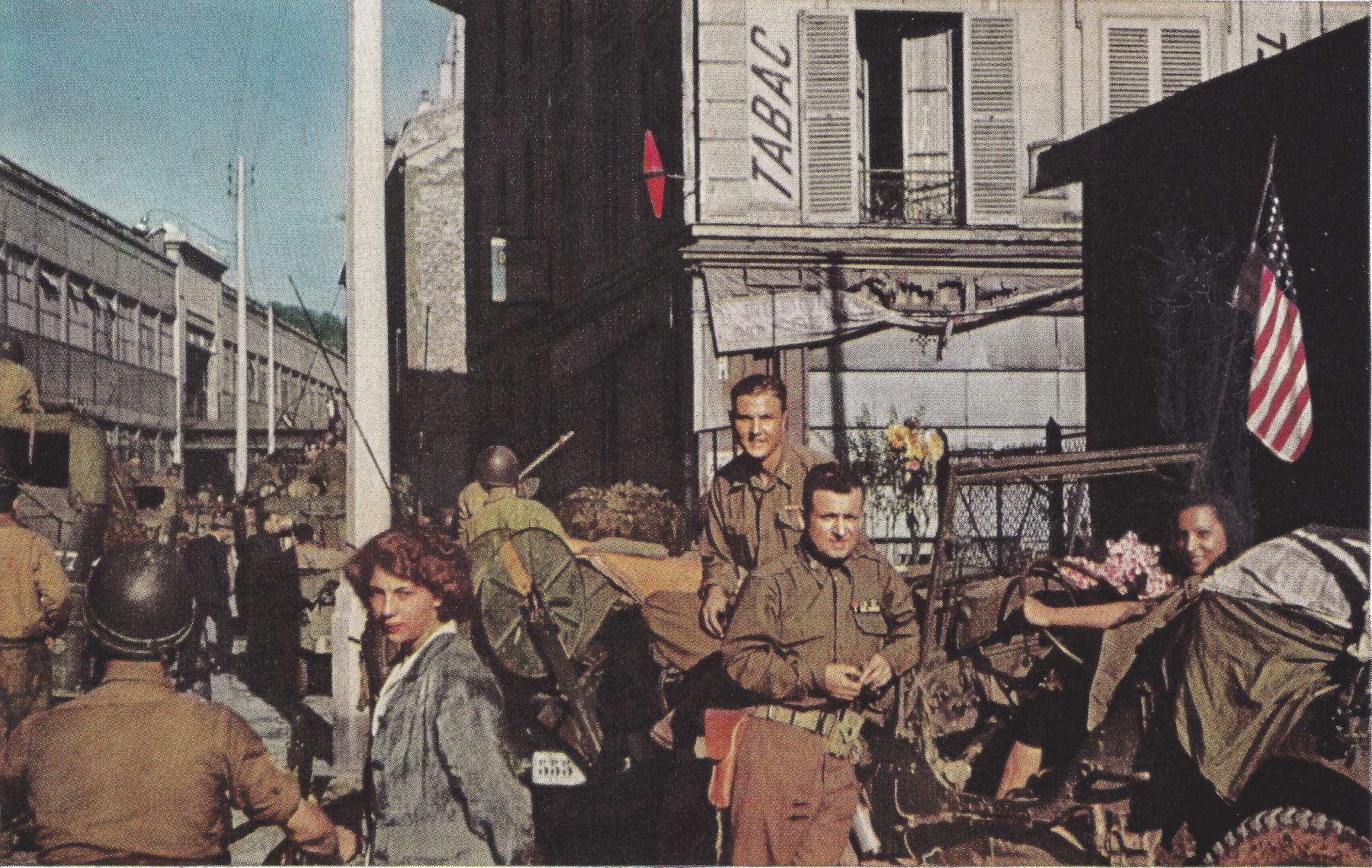 The jeep that carried the first American flag into Paris: Ernest Hemingway took this photo of the author in the center with  the regular driver, Capt. John Westover, behind. The senrita Elena sits at the wheel. At the left is the Renault plant. Photo: collection of the author.