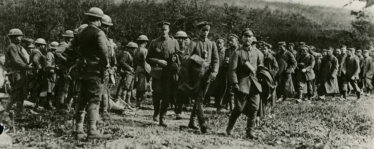 German officers pass American officers counting prisoners taken by York, who can be seen still wearing his helmet behind the three German officers in the center. Courtesy University of Kentucky Press.