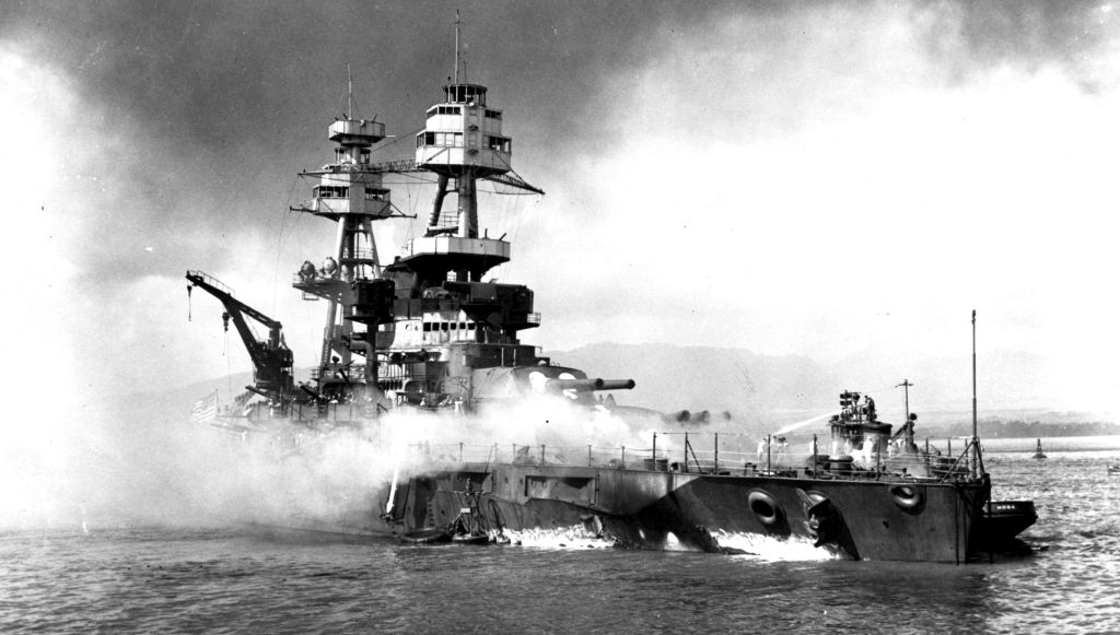nderway at Pearl Harbor, USS Nevada was hit by multiple bombs and torpedoes, and temporarily beached on Hospital Point to keep her from sinking too deep. National Archives.
