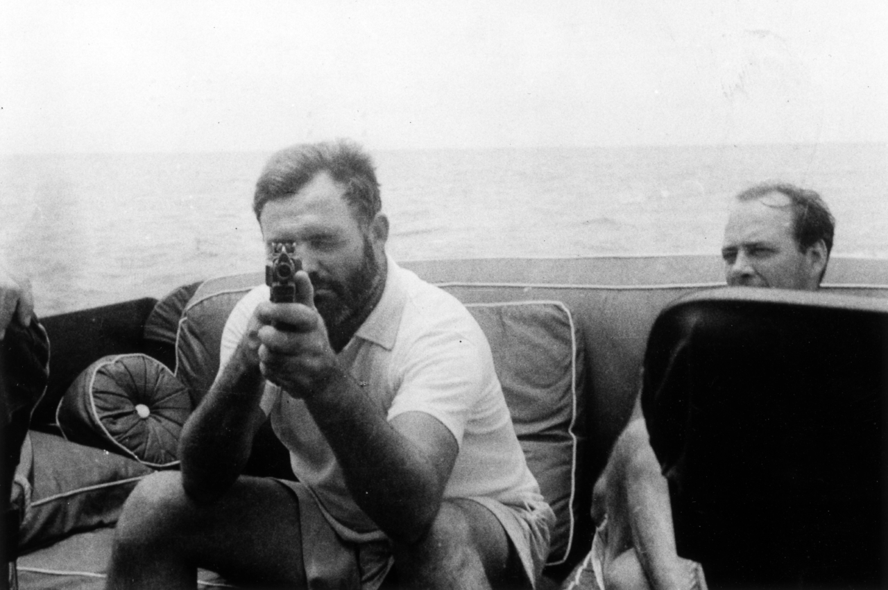 Ernest Hemingway with a Thompson submachine gun aboard the Pilar in 1935.